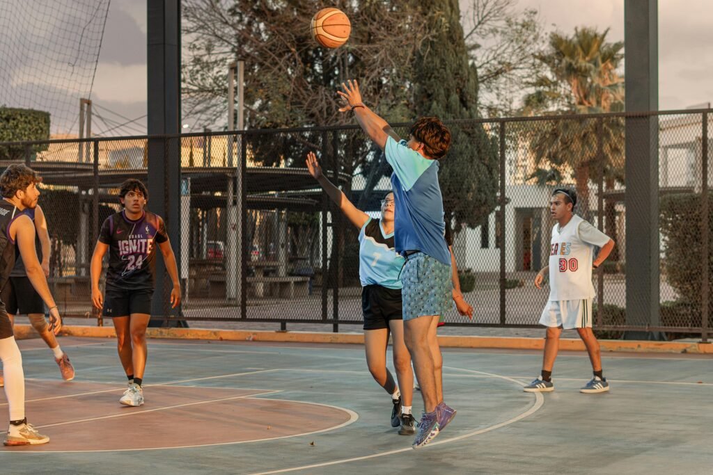 High-energy outdoor basketball game with players shooting and defending on a street court.